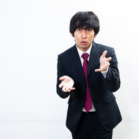 真剣に想いを伝える会社員のジェスチャー・力説する男性の写真