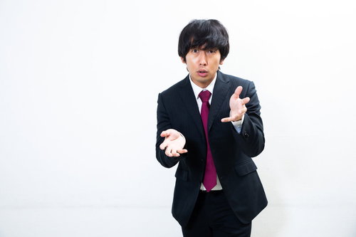 真剣に想いを伝える会社員のジェスチャー・力説する男性