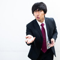 相手に訴えかける演説者の男性がマイクで熱弁を振るうの写真