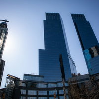 青空を背景にしたニューヨークのガラス張り高層ビル群の写真