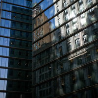 ニューヨークの高層ビルのガラス窓に反射する街並みの写真