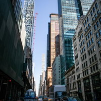 ニューヨークの高層ビル群を走るイエローキャブの写真