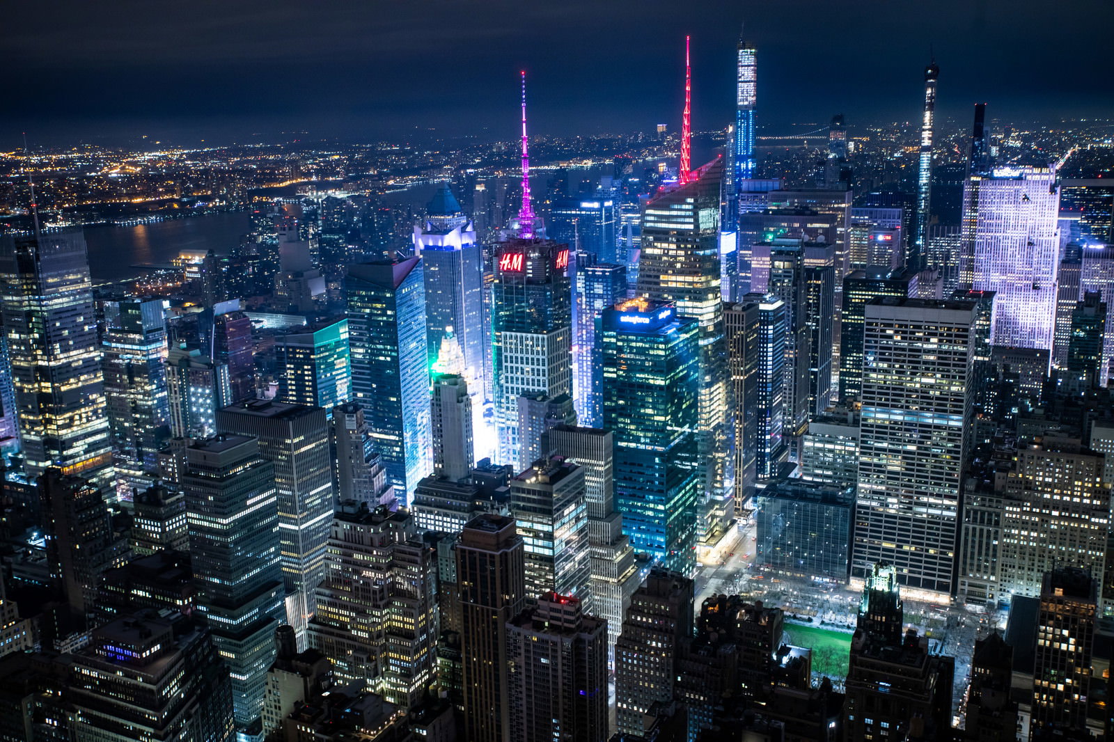 青やピンクの光に照らされたニューヨークの高層ビル群の夜景
