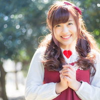 ハートのキャンディを持った森ガール女性の笑顔ポートレートの写真