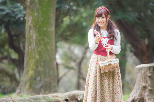 森でバスケットを持ち笑顔で小瓶を売る少女