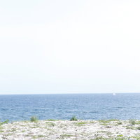 誰もいない静かな海とヨット、広がる水平線の写真