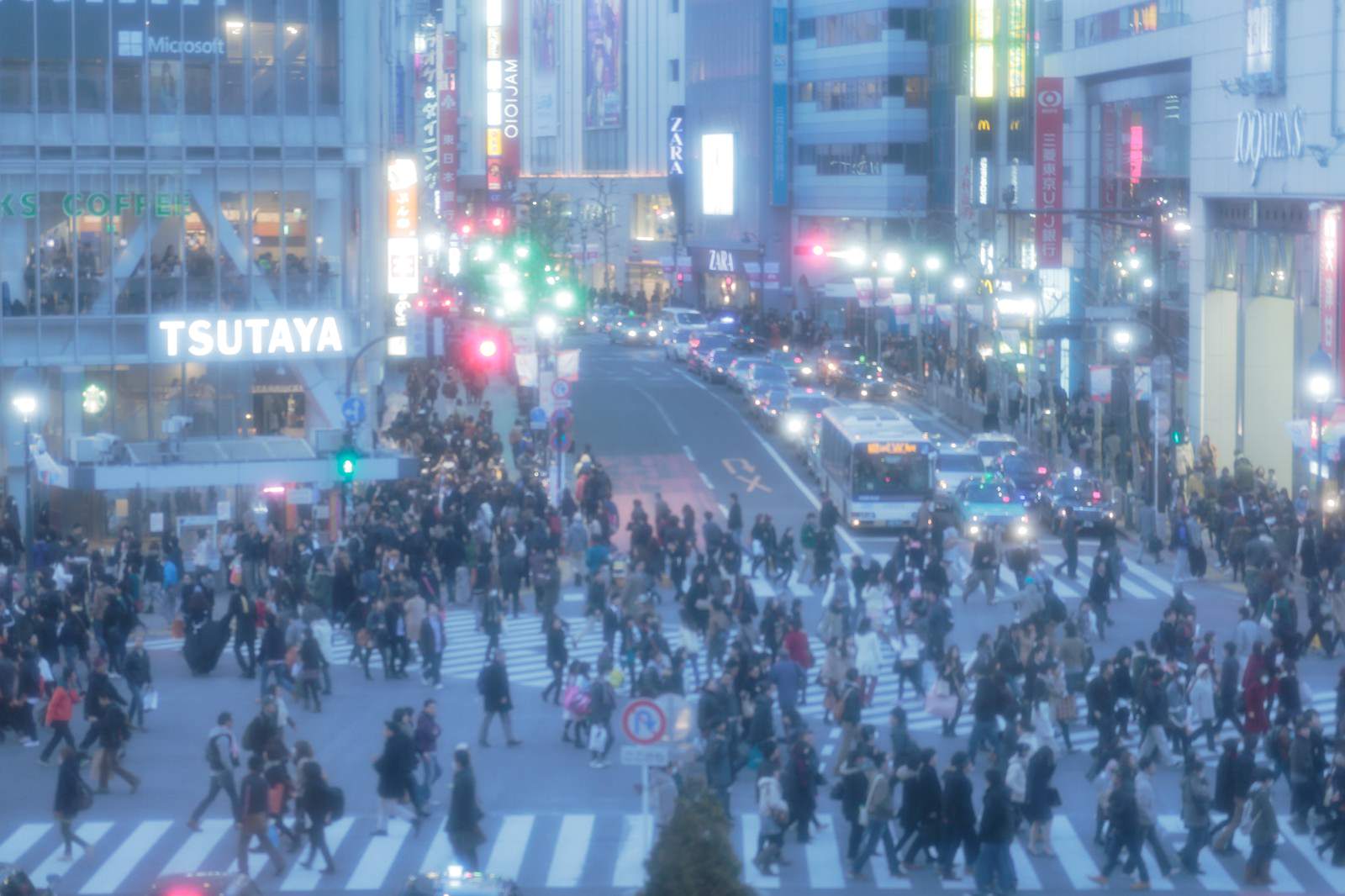 渋谷スクランブル交差点で人々が横断歩道を行き交う夜間の風景