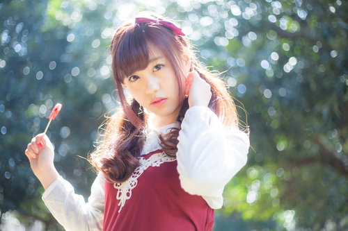 あれ・・道に迷ったみたい、森の中で飴をくわえる女性