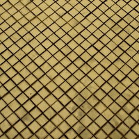 黒い斜め格子模様が並ぶ黄色いタイル表面のテクスチャーの写真