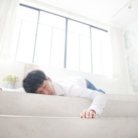 自宅についた安心感で安らかに眠るデザイナー男性の写真