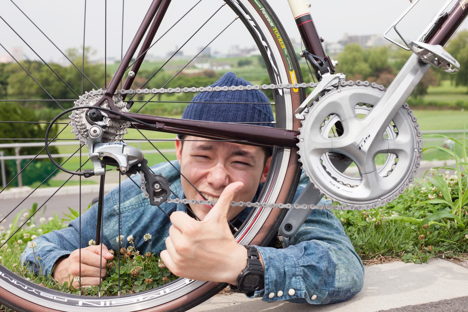 ロードバイクのコンポーネントをおすすめする青いジャケットの男性［モデル：けんたさん］