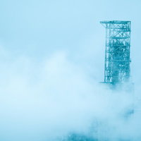 霧に包まれた工場の煙突の写真