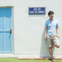 フランスの街角で待ち合わせ場所に早く来てしまい待ちぼうけする男性の写真