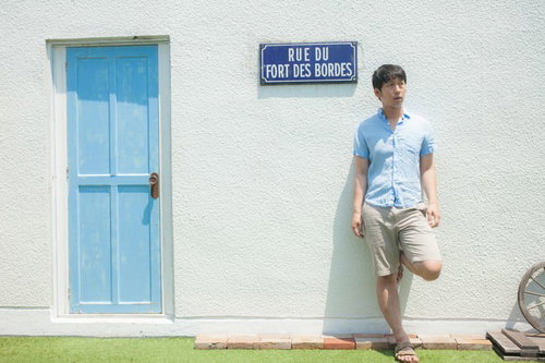 フランスの街角で待ち合わせ場所に早く来てしまい待ちぼうけする男性