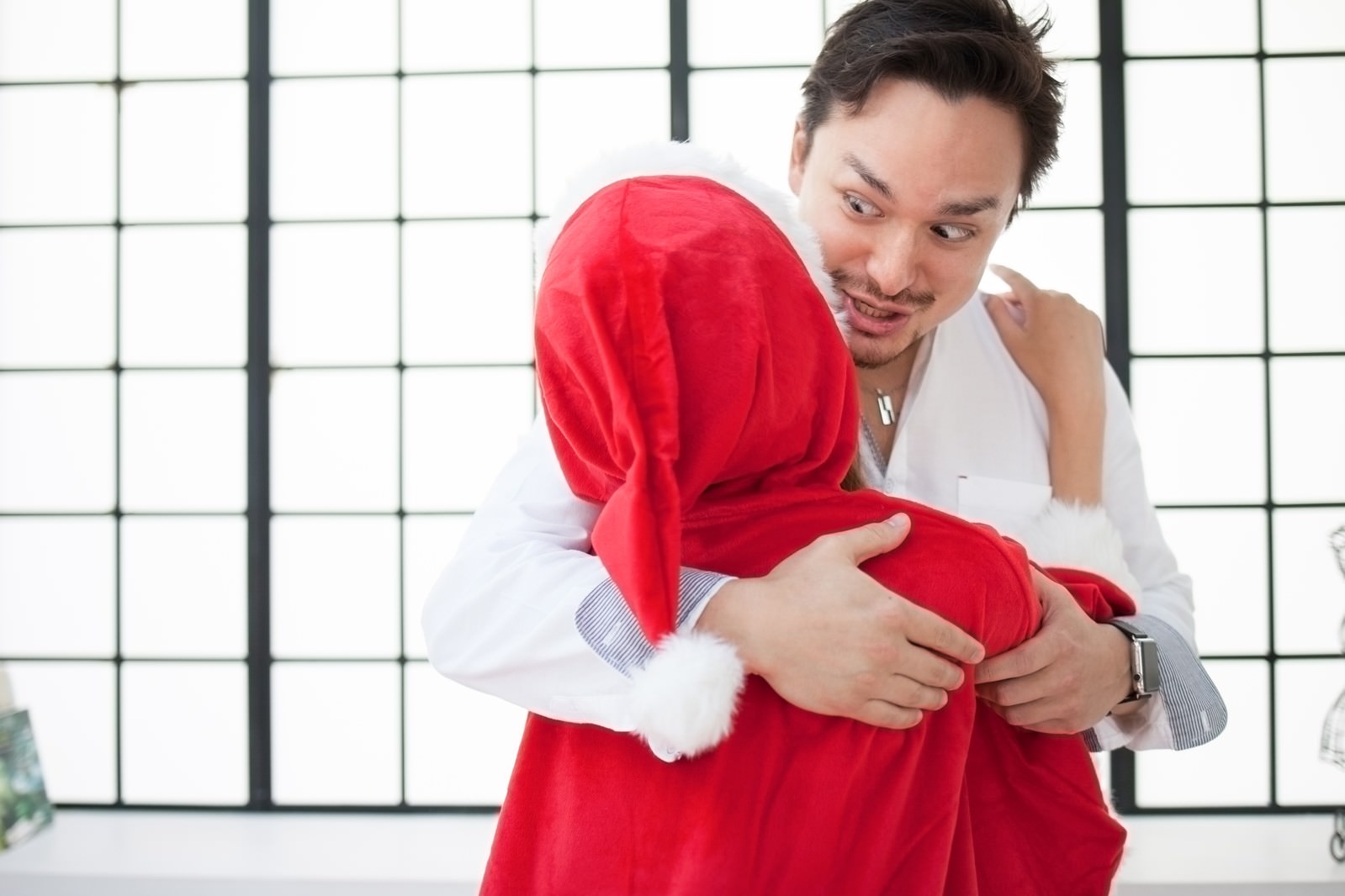 赤いサンタ衣装の女性を抱きしめる男性の様子［モデル：Max_Ezaki］