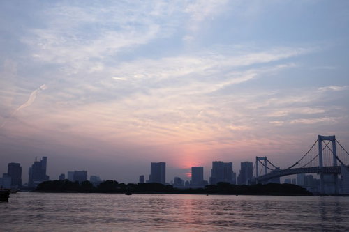 夕焼けに染まる東京お台場のレインボーブリッジと都市風景