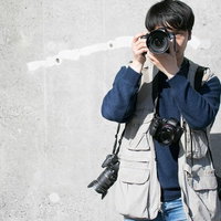 複数台のカメラを装備する男性カメラマンの報道撮影の写真