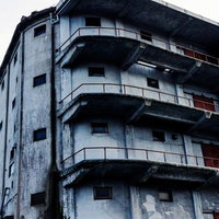 曇り空の下に立つ廃墟の古い倉庫の写真