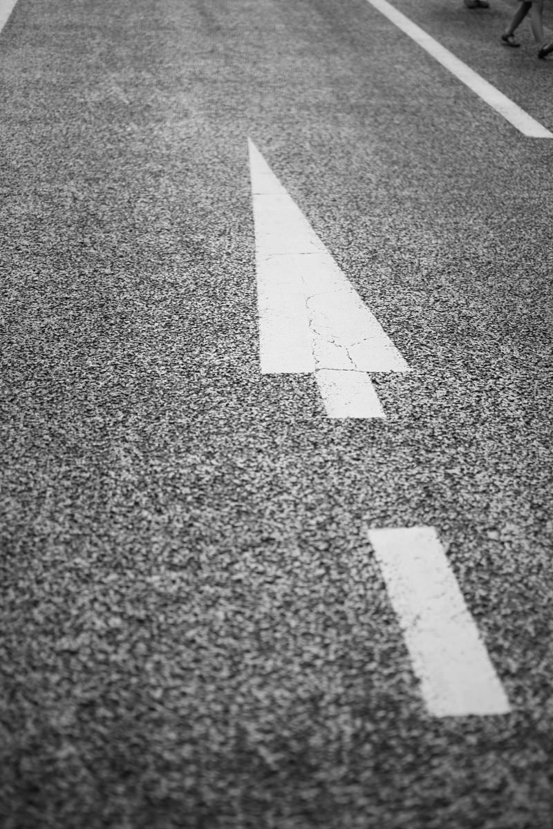 アスファルトの道路に描かれた白い三角の矢印と長方形のマーキング