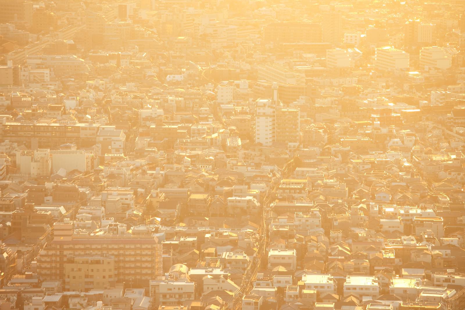 黄色い靄に包まれた密集する東京住宅街の夕焼けの遠景