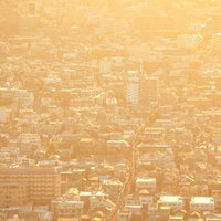 黄色い靄に覆われた密集する東京住宅街の夕焼けの遠景の写真
