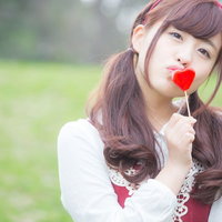 ハート型キャンディにキスする女の子のポートレートの写真