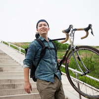 ロードバイクを肩に担ぐ自転車男子が階段を上るの写真