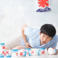 かき氷を食べ過ぎて腹痛に苦しむ男性の夏の体調不良の写真