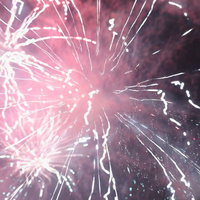 花火・夏の終わりのピンク色の光と夜空の対比の写真