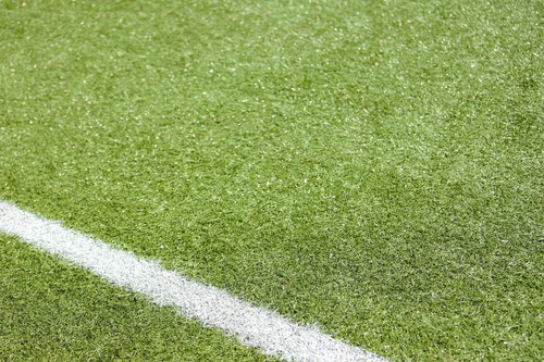 緑の芝生に引かれた白い直線のスポーツフィールドライン