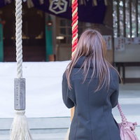 神社で参拝する女性の後ろ姿の写真
