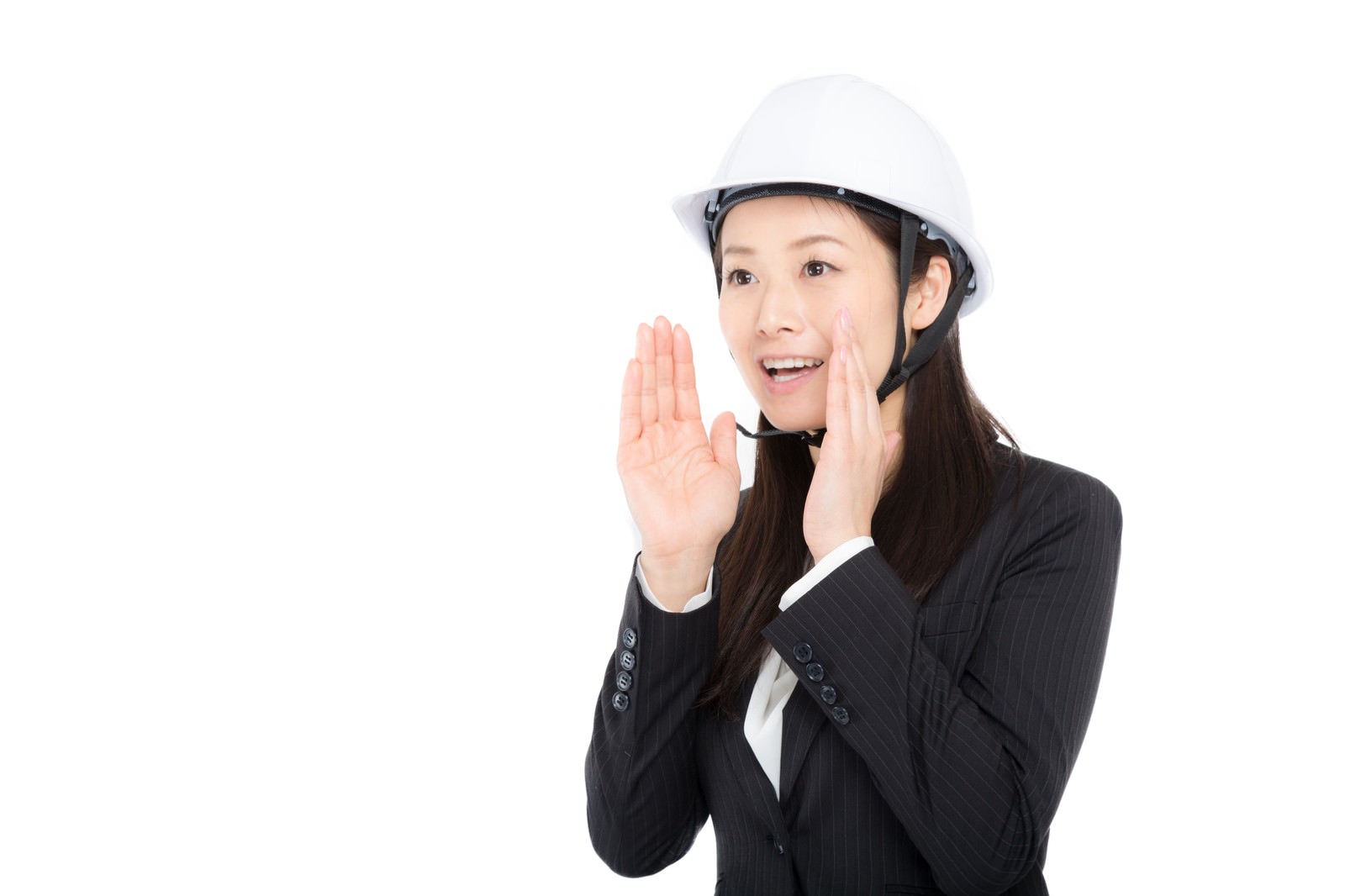 白いヘルメットをかぶり両手で声を出すビジネススーツ姿の女性［モデル：土本寛子］