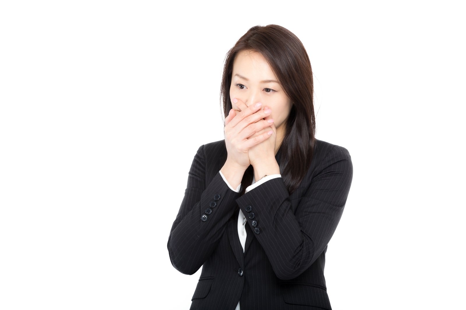 口に手を当てて絶句する黒いスーツを着た女性［モデル：土本寛子］