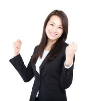 新入社員にエールを贈るスーツ姿の女上司のガッツポーズの写真