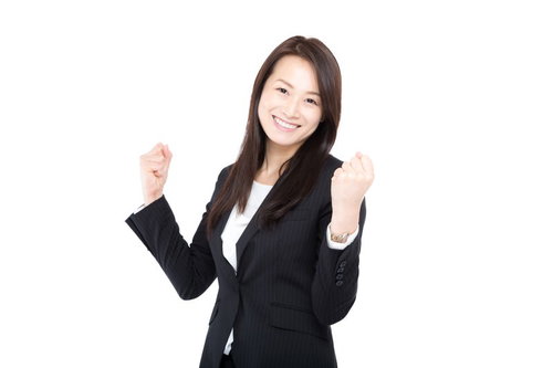 新入社員にエールを贈るスーツ姿の女上司のガッツポーズ