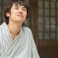 浴衣姿で縁側に座る男性の写真