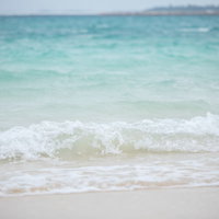 宮古島の波打ち際でザパーと打ち寄せるエメラルドグリーンの波の写真