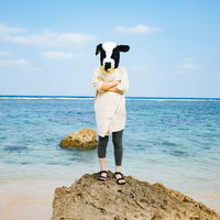 旅行中でも気を抜かない牛女、宮古島の海辺での堂々とした姿勢の写真