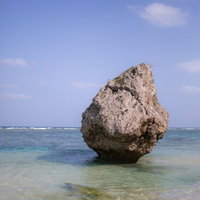 宮古島の透明なエメラルドグリーンの海と海岸の岩の写真