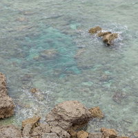 宮古島のゴツゴツした岩場と透き通るエメラルドグリーンの海の写真
