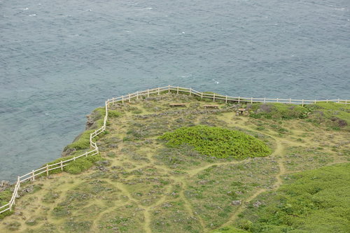 東平安名崎灯台からの景観、芝生に設置された木製ベンチと青い海