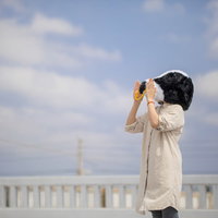 白いコートを着て牛への想いを力強く叫ぶ女性の写真