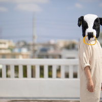屋上で立ちすくむ牛女のシュールなコスプレの写真