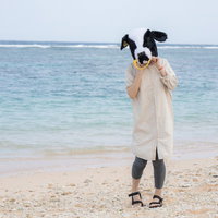 宮古島の砂浜で牛のかぶりものを被ってはしゃぐ女性の写真