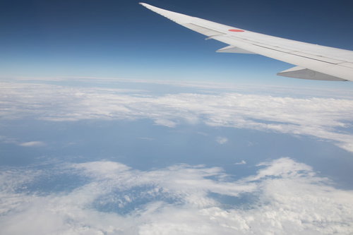 旅客機の翼と上空から見える雲海の景色 雲の層と青空