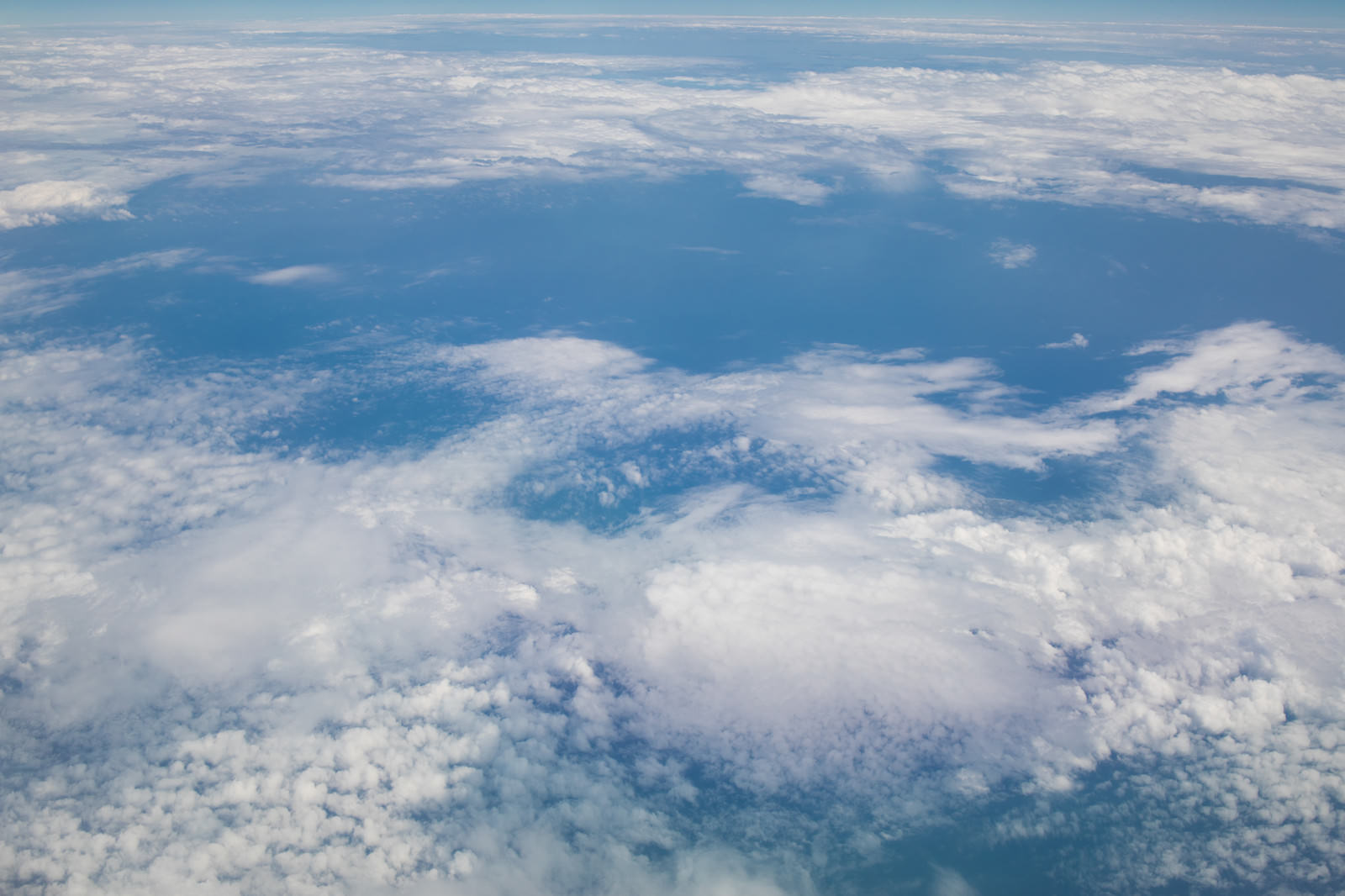 飛行機の窓から見た雲海と青空