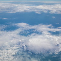 上空から見下ろす青い空と雲海の写真