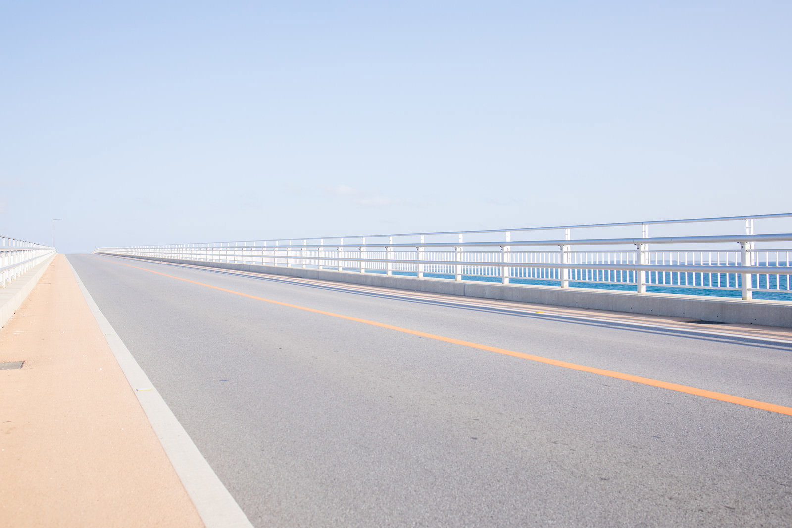 青い海と空を背景に真っ直ぐ延びる伊良部大橋の道路