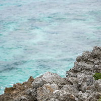 宮古島の岩場と透き通る海の絶景、波が打ちつける自然風景の写真