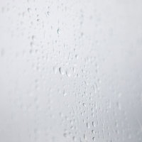 雨の日の窓ガラスに付いた水滴の写真